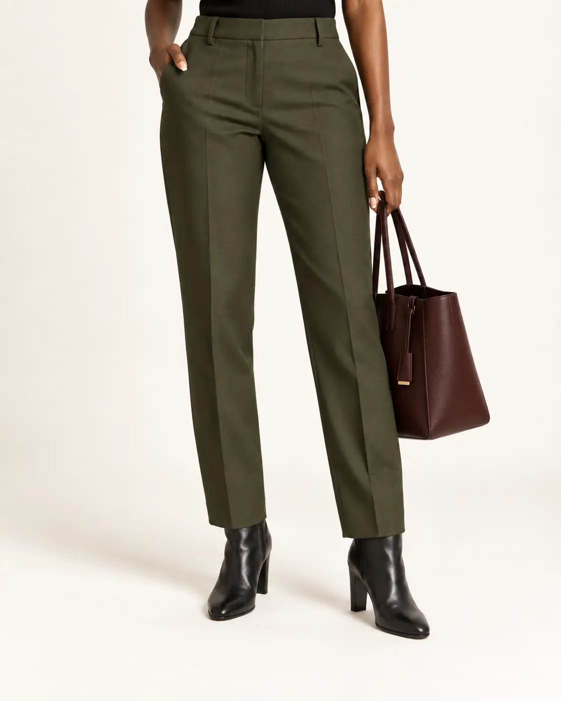 Olive tapered work pants worn with polished black block-heel ankle boots